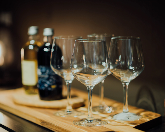 wine glasses on a wooden board with oil