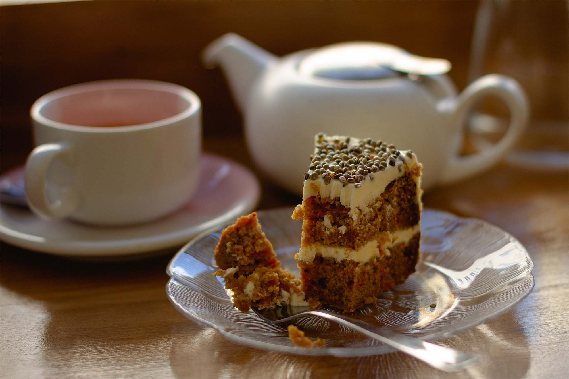 a teapot, mug and slice of carrot cake