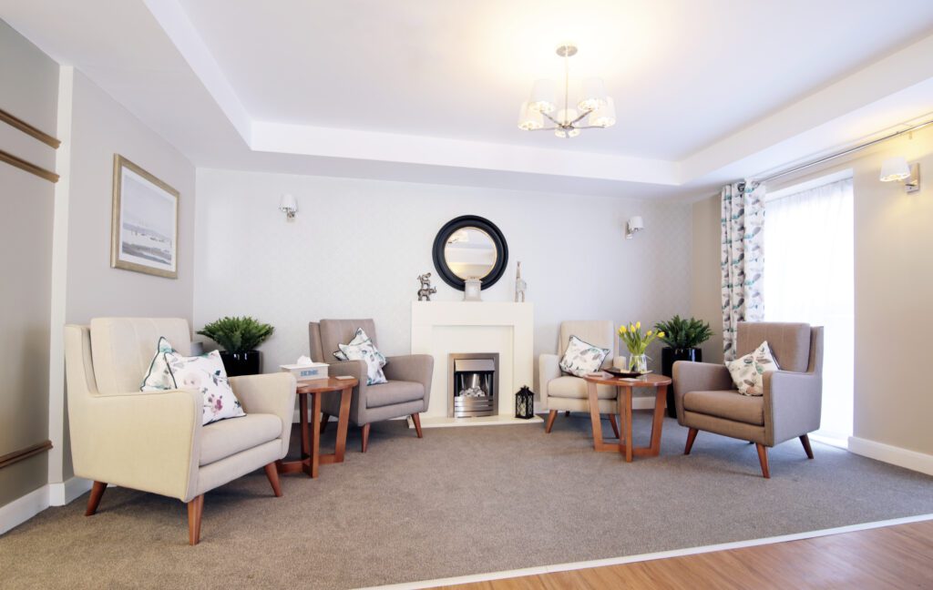 one of our lounges with comfortable armchairs, a sofa and a fireplace