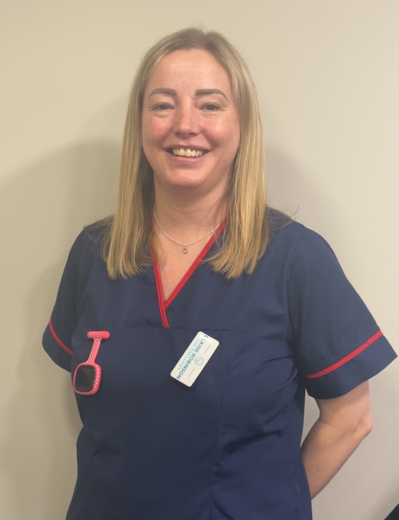 woman with blonde hair smiling wearing a blue and red team leader uniform having her photo taken for the team page