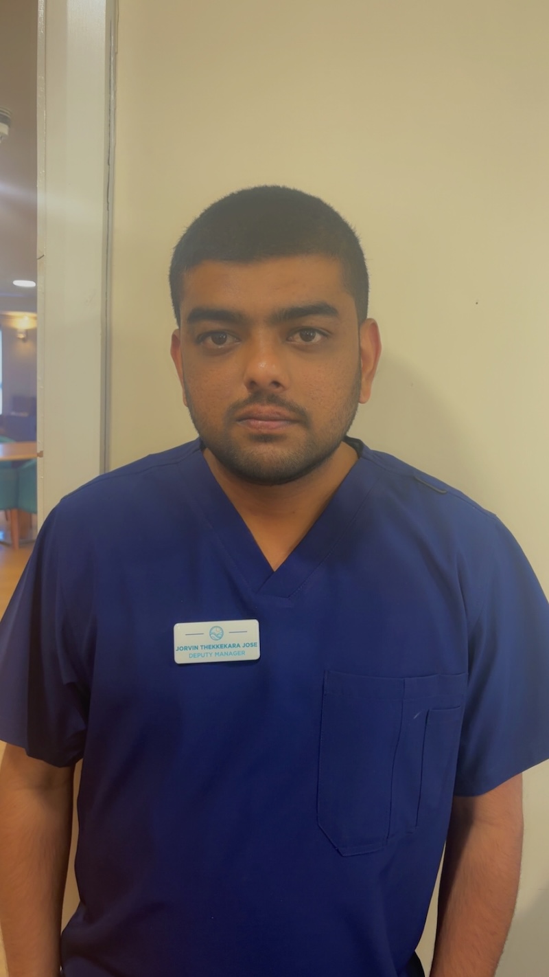 man with brown hair wearing a dark blue uniform