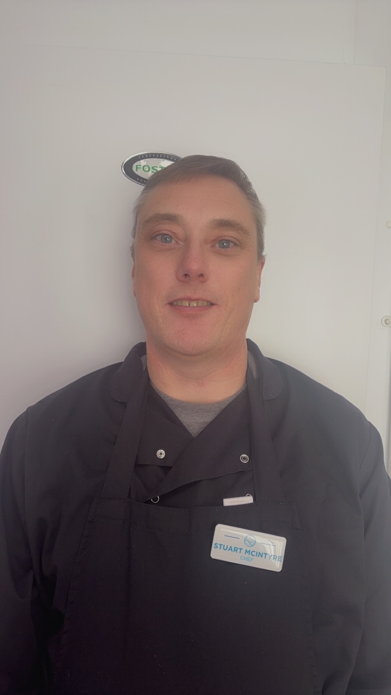 our head chef wearing chef blacks having his headshot taken for our team page